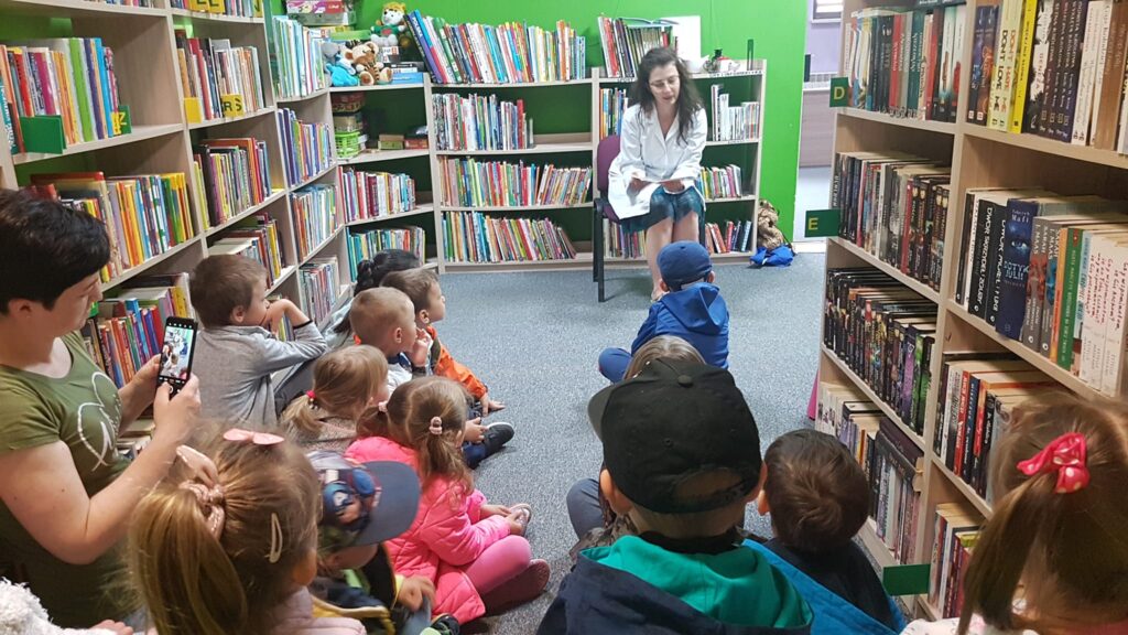 Ogólnopolski Tydzień Czytania Dzieciom. farmaceutka czyta dzieciom w bibliotece