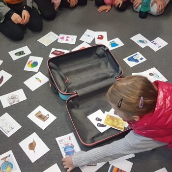 Odkrywcy na tropie przygód. dzieci na podłodze wokół walizki