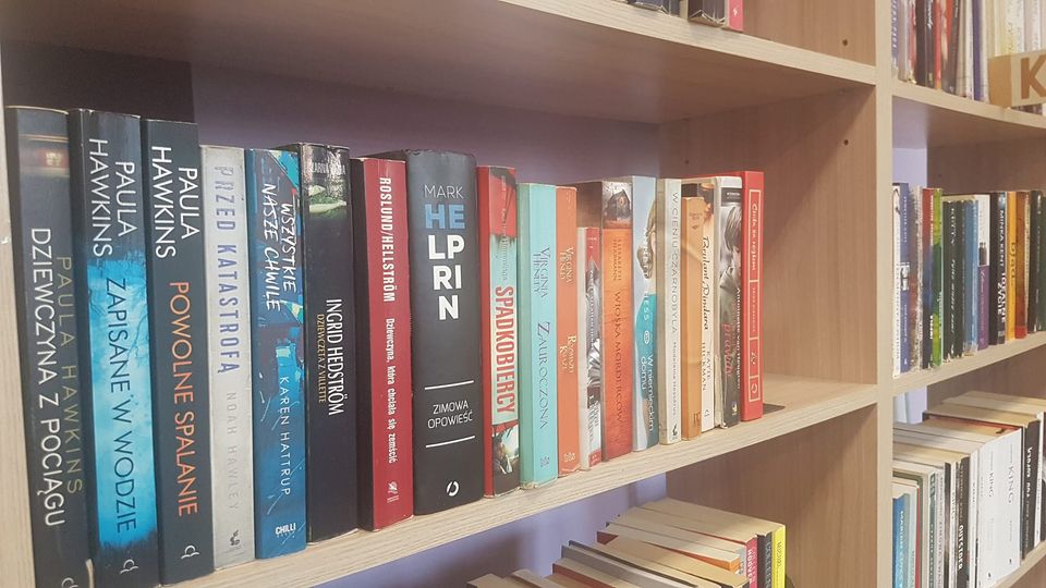 Półka z książkami w bibliotece. Najchętniej wypożyczane w 2022 r.