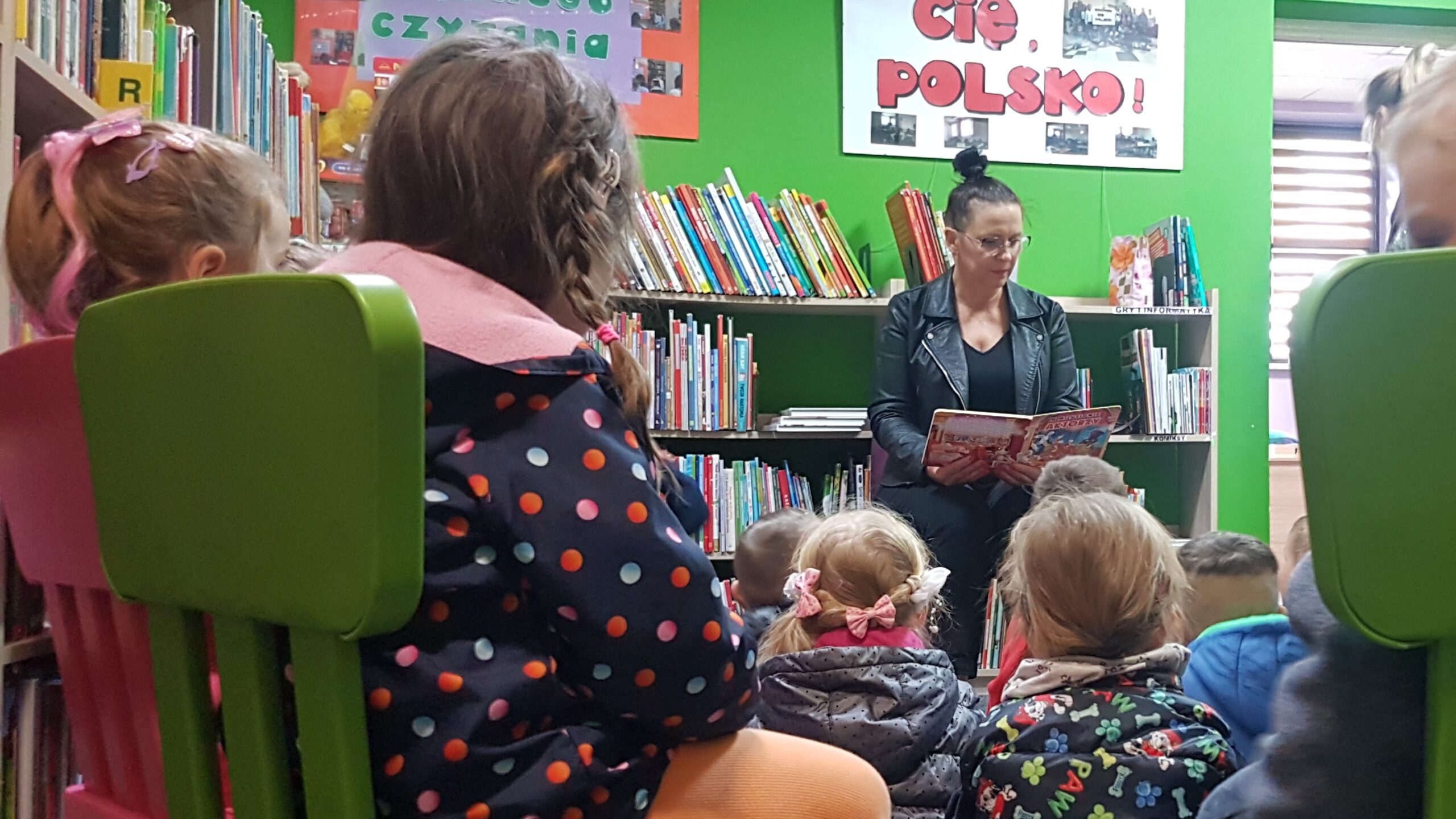 Spotkanie z animatorem kultury. Kobieta czyta dzieciom w bibliotece