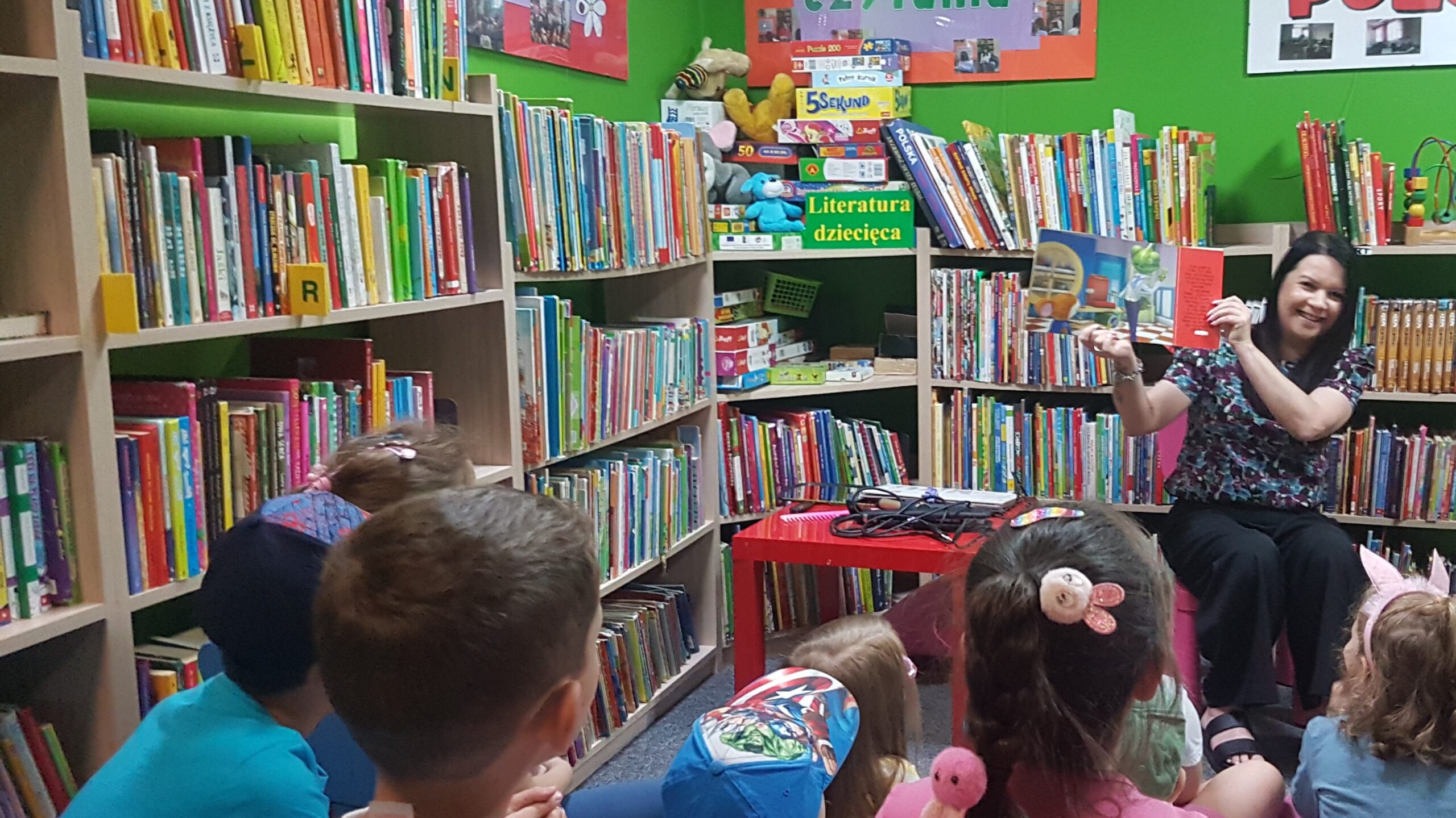 Spotkanie z fryzjerką. Kobieta czyta dzieciom w bibliotece.